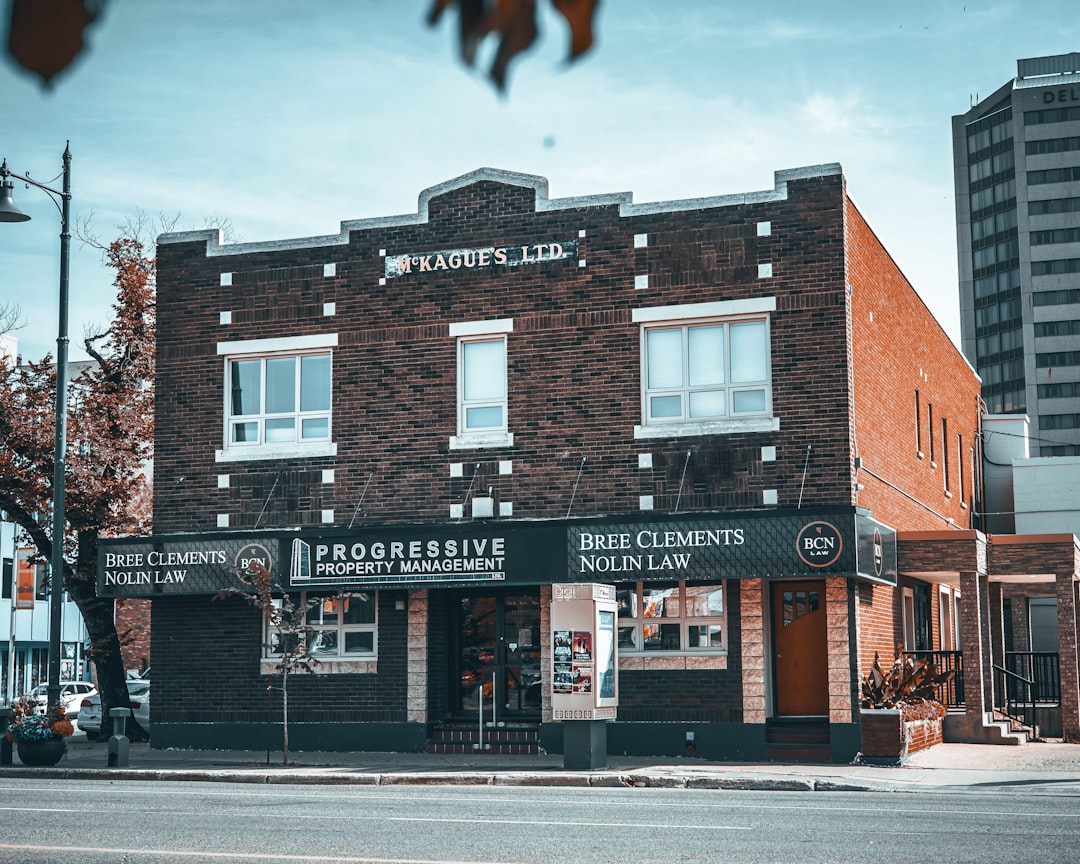 Brick building with "progressive property management" sign.