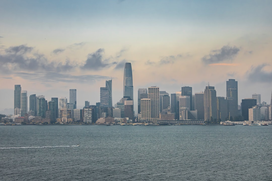 City skyline across the water with a boat.