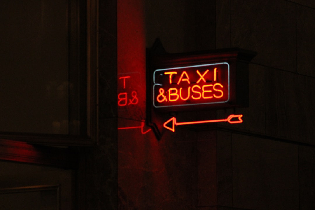 a red taxi sign hanging from the side of a building