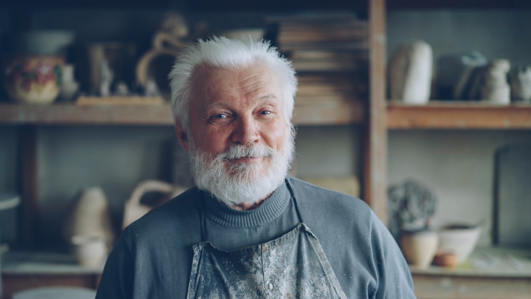 A smiling, older potter in his workshop.