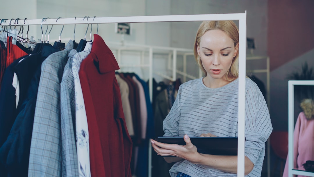 Woman reviews garments in clothing store.